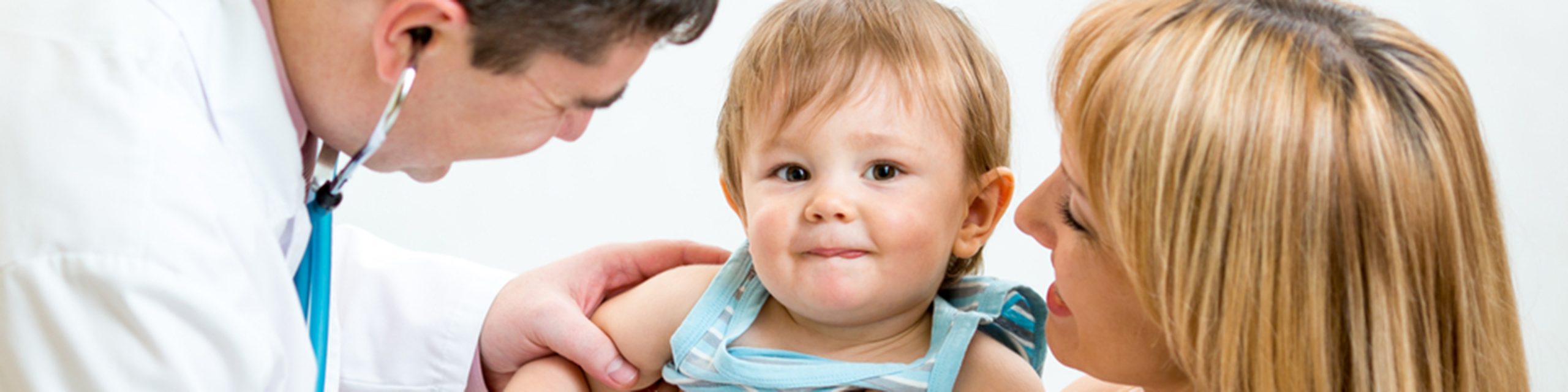 Doctor examining a baby with parent